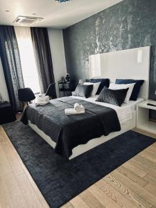 a bedroom with a large bed with a black accent wall at B&B Skyfall in Split