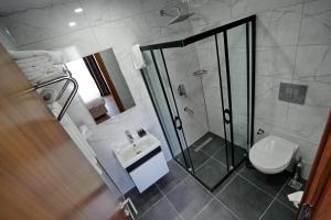 a bathroom with a shower and a toilet and a sink at Shelton Airport Hotel in Arnavutköy +43 photos