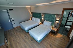 um quarto de hotel com duas camas e uma casa de banho em Shelton Airport Otel em Arnavutköy