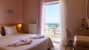 a hotel room with a bed and a large window at Vakakis-ME Apartments in Palaiochora