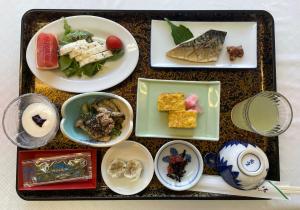 ein Tablett mit Teller mit Lebensmitteln auf einem Tisch in der Unterkunft Togawaso in Fujikawaguchiko