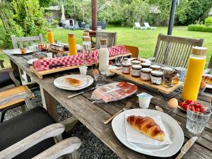 a wooden table with plates of food on it at Villa Vallière bed&breakfast in Vallières