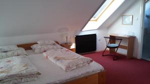 a bedroom with two beds and a desk and a window at Polgármester Étterem és Panzió in Fertőszéplak