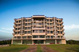 ein großes Apartmenthaus auf einem Rasenplatz in der Unterkunft Hotel Orchid Blue in Ināni