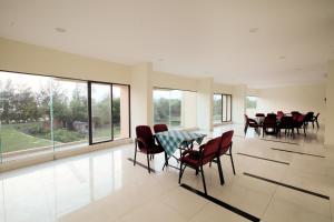 a dining room with a table and chairs and windows at Hotel Orchid Blue in Ināni