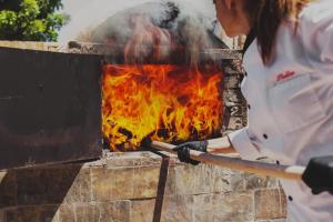 una mujer está cocinando en un horno de ladrillo en Latchi Escape Hotel and Suites - By IMH Travel & Tours en Neo Chorio