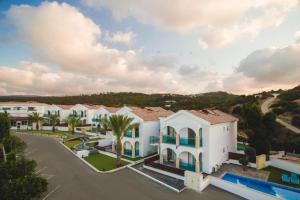 ariale Aussicht auf ein großes weißes Gebäude mit Palmen in der Unterkunft Latchi Escape Hotel and Suites - By IMH Travel & Tours in Neo Chorio