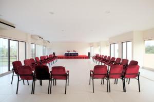 ein leeres Zimmer mit roten Stühlen und einem Tisch in der Unterkunft Hotel Orchid Blue in Ināni