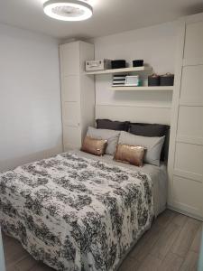 a bedroom with a bed with a black and white comforter at PRECIOSO APTO 1 LINEA PLAYA VISTAS AL MAR in Sitio de Calahonda