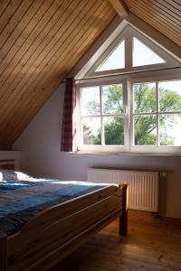 a bedroom with a bed and a large window at Ferienwohnung Brunkhorst in Krakvitz in Putbus