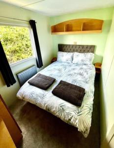 uma cama num pequeno quarto com uma janela em Woodland Forge Lodge 