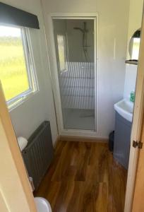 een badkamer met een douche, een toilet en een wastafel bij Woodland Forge Lodge 
