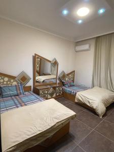 - une chambre avec 2 lits et un miroir dans l'établissement Modern Apartment 3 room in Sheikh Zayed N5 الشيخ زايد, à Ville du 6 Octobre