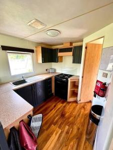 uma pequena cozinha com um lavatório e um fogão em Woodland Forge Lodge 