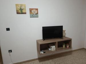 TV de pantalla plana en la parte superior de un centro de entretenimiento de madera en Dà Nonna Lisa, en Castel San Lorenzo