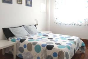 a bedroom with a bed with a polka dot blanket at Sol, mar y naturaleza in Pontevedra +34 photos