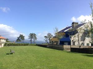 a grassy yard with a house and a building at Sol, mar y naturaleza in Pontevedra
