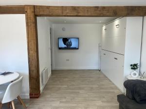 un soggiorno con un tavolo e una TV a parete di Acorn Lodge a Eastergate