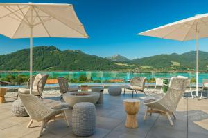 a patio with chairs and tables and umbrellas at Caro & Selig, Tegernsee, Autograph Collection in Tegernsee