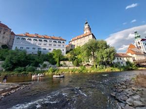 people in boats on a river with buildings in the background at Villa Celnice in Český Krumlov