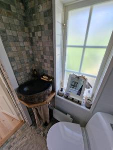 uma casa de banho com um WC, uma janela e um lavatório. em Seglarevistet 2 em Domsten