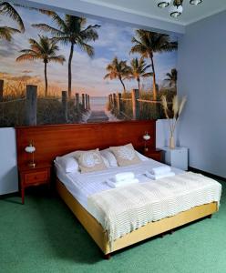 a bedroom with a bed with a painting of a beach at Senator Gran Via in Będziemyśl