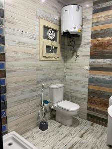 La salle de bains est pourvue de toilettes, d'un lavabo et d'un ventilateur. dans l'établissement Modern Apartment 3 room in Sheikh Zayed N5 الشيخ زايد, à Ville du 6 Octobre