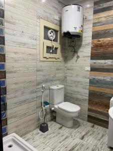 a bathroom with a toilet and a sink and a fan at Modern Apartment 3 room in Sheikh Zayed N5 الشيخ زايد in 6th Of October
