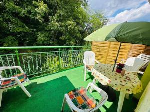 a balcony with chairs and a table and an umbrella at Apartment Lilianna in Karlovy Vary