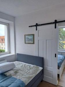 1 dormitorio con 1 cama y puerta con ventana en Apartament z Napoleonem w tle en Lidzbark Warmiński