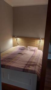 a bedroom with a bed with a striped blanket at Apartament CENTRUM in Giżycko
