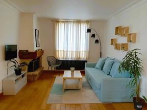 a living room with a blue couch and a table at VILLA CLARETTE in Carhaix-Plouguer