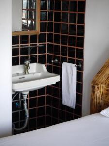 a bathroom with a sink and a mirror at Hostel & Surfcamp 55 in Ericeira +37 photos