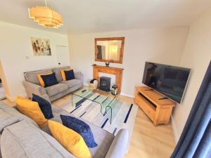 a living room with a couch and a television at 12 Ivy Cottage in St Ives