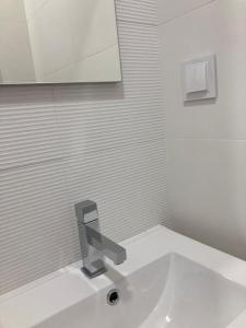 a bathroom with a sink with a faucet at Apartamento Renovado no Centro da Cidade - Casa4 in Coimbra