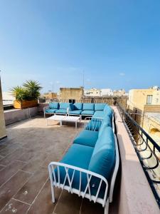 rząd niebieskich ławek siedzących na dachu w obiekcie My Travel House w mieście Rabat