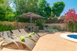 a patio with chairs and a table and a pool at Villa Son Serra in Son Serra de Marina