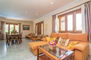 a living room with a couch and a table at Villa Son Serra in Son Serra de Marina