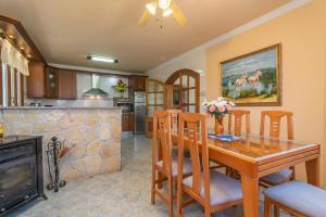 a kitchen and dining room with a table and a fireplace at Villa Son Serra in Son Serra de Marina