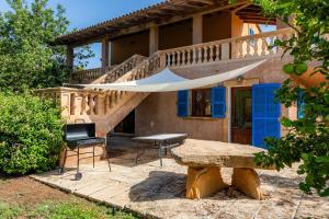 a house with a table and a wooden staircase at Sa Plana in Son Servera