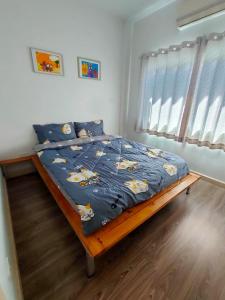 een slaapkamer met een bed met een blauw dekbed erop bij บ้านไอรักbyเดอะนีโอ 