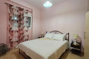 um quarto com uma cama branca e uma parede rosa em Amazing seafront house with private beach em Paránimfoi