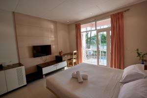 a bedroom with a bed and a tv and a window at Foy's Lake Resort in Chittagong