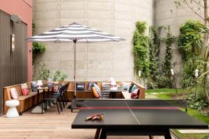 a patio with a table and an umbrella at Moxy Bordeaux in Bordeaux