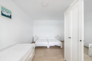 biała sypialnia z 2 łóżkami i lustrem w obiekcie Casa Daura Playa de Arinaga 2023 Reformed w mieście Arinaga
