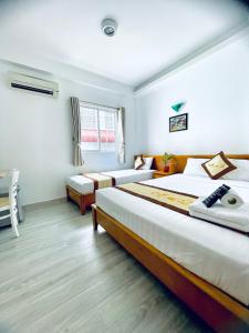 a hotel room with two beds and a window at Marieline Hotel Pham Ngu Lao in Ho Chi Minh City