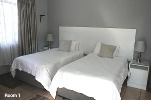 dos camas sentadas una al lado de la otra en un dormitorio en Purdy's Place, en Louis Trichardt