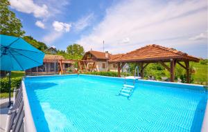 a swimming pool with a chair and an umbrella at 2 Bedroom Cozy Home In Hrastovica 