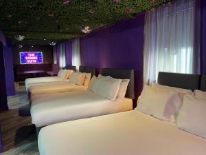 a row of beds in a room with a tv at Hotel 105 in Liverpool