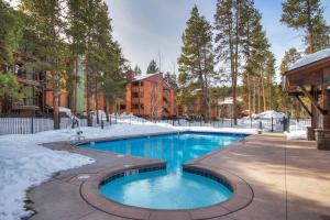 a swimming pool in a yard with snow on the ground at Two Bedroom Condo with Parking, Pool, Hot Tub - Steps to Main Street in Breckenridge